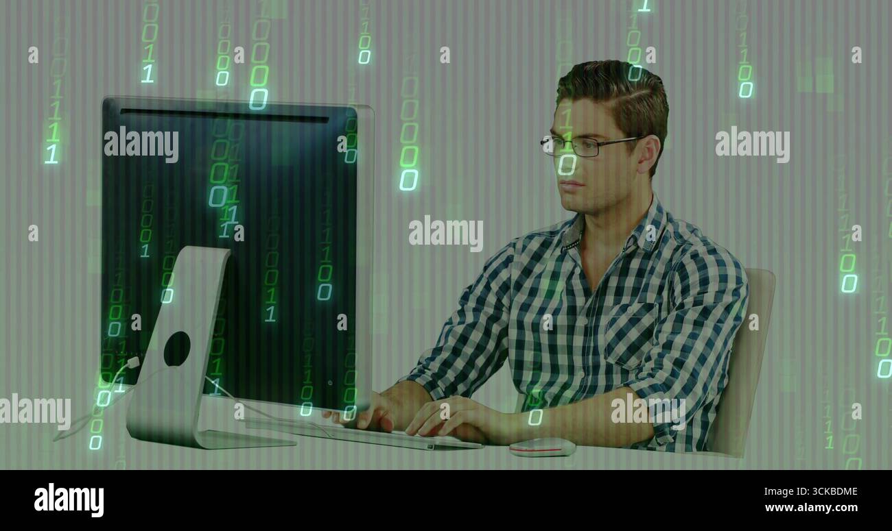 Typing man wearing checkered shirt using computer setup at office desk with binary overlay. Technology, programming, innovation, digital, workspace, m Stock Photo