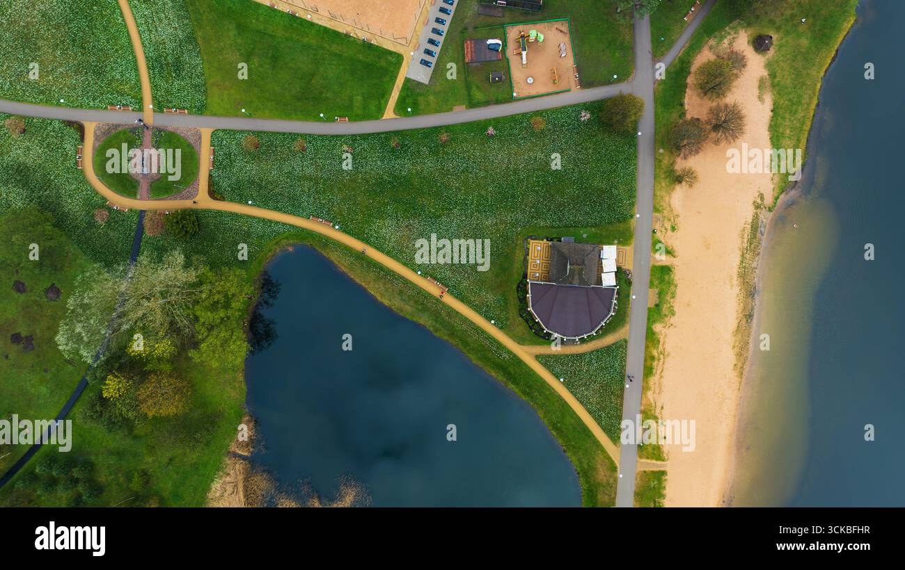 Aerial view of a park featuring a lake, sandy pathways, a circular ...