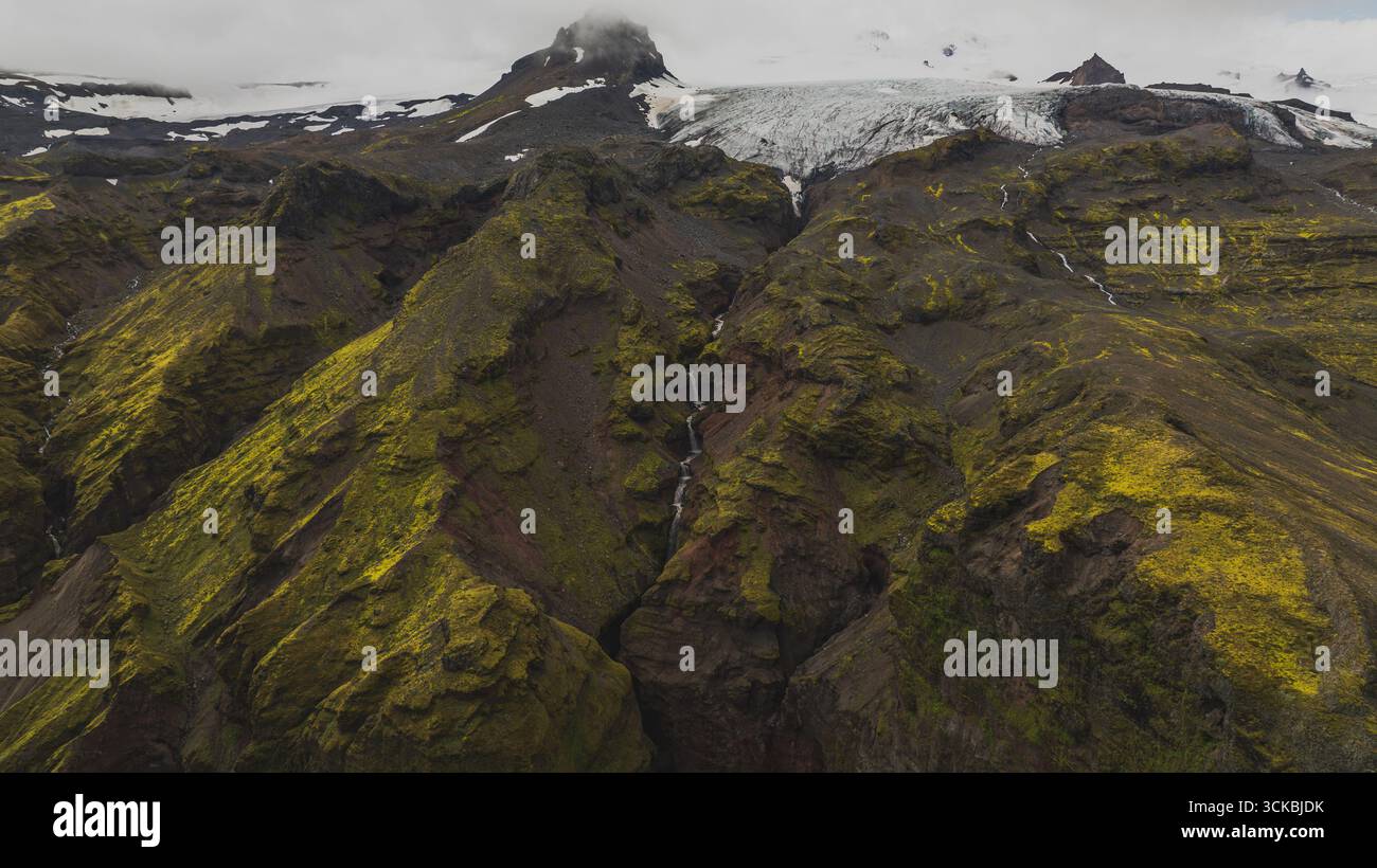 Dramatic aerial view of moss covered volcanic ridges with cascading ...