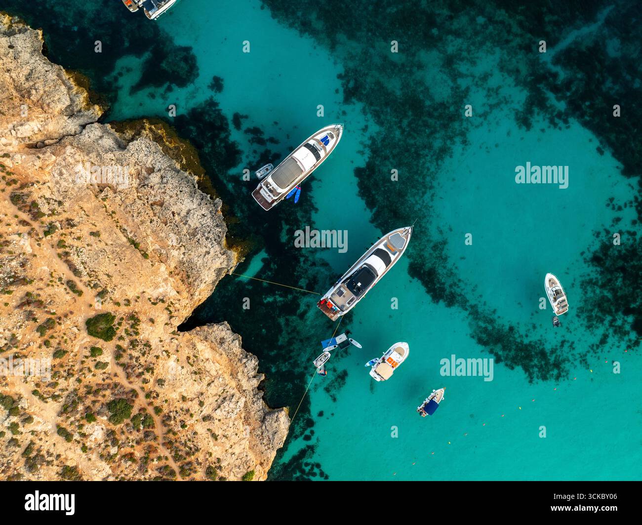 Aerial view of yachts floating on the turquoise waters near rugged ...