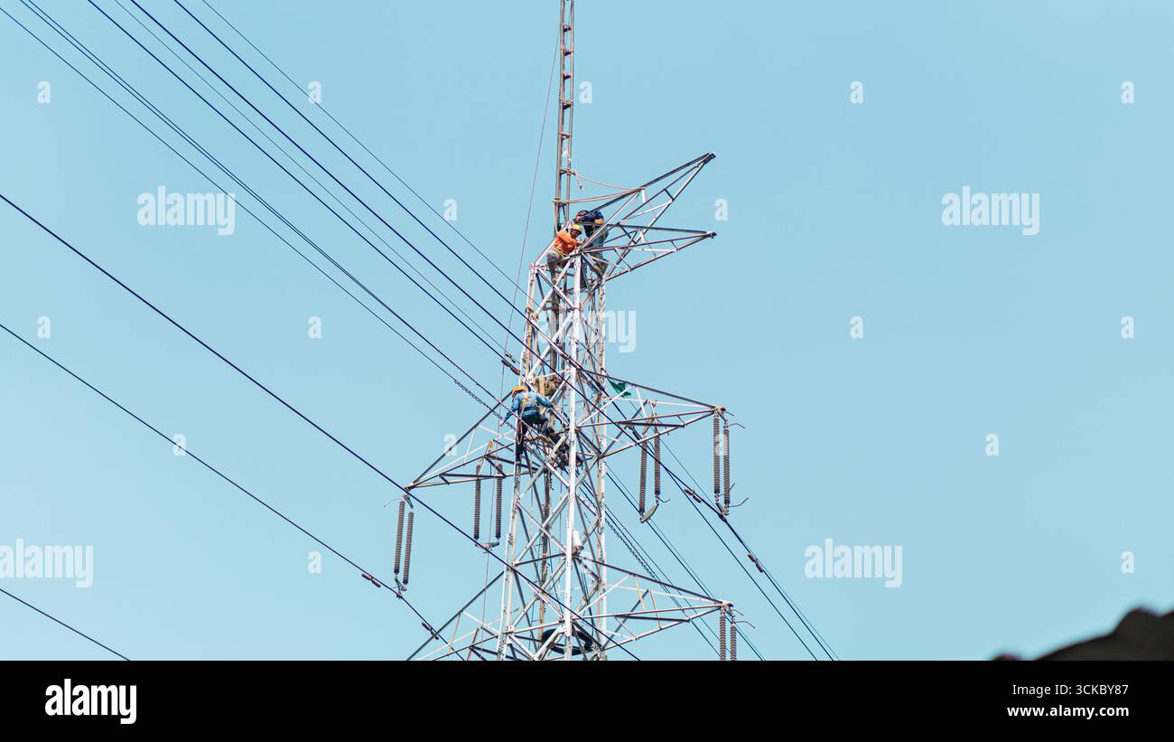 Worker installing a high-voltage electrical panel frame, showcasing ...