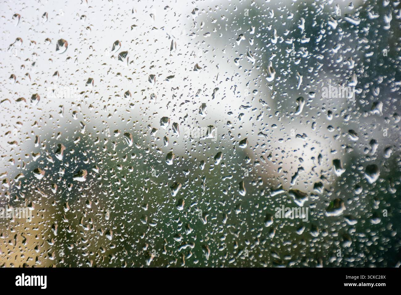 wet window background. rain drop on the glass surface. bad weather concept. urban landscape blurred in the distance Stock Photo
