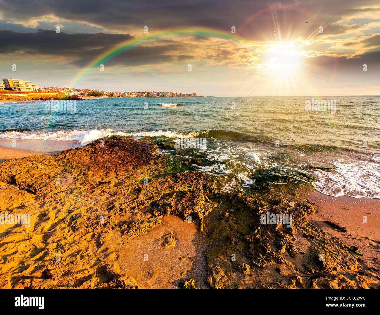 sunrise on a sandy town beach in mellow season at sunset. beautiful and warm weather on the shores of black sea. coast in evening light Stock Photo