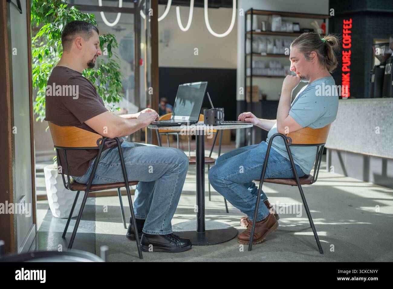 Two It Software engineers working on project and programming in coffee shop. Business people concept. Stock Photo