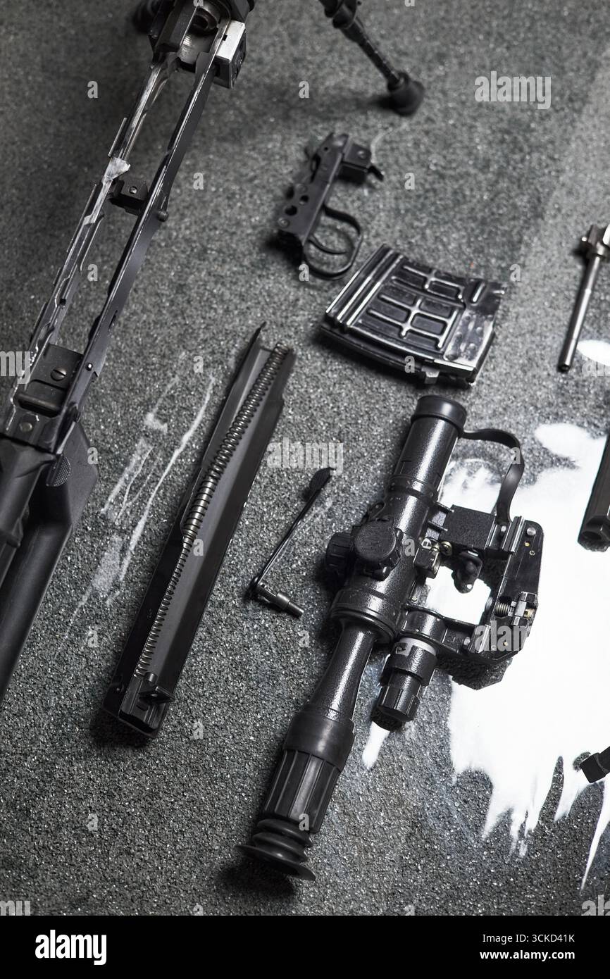 Disassembled assault rifle with visible magazine, optical scope, barrel ...