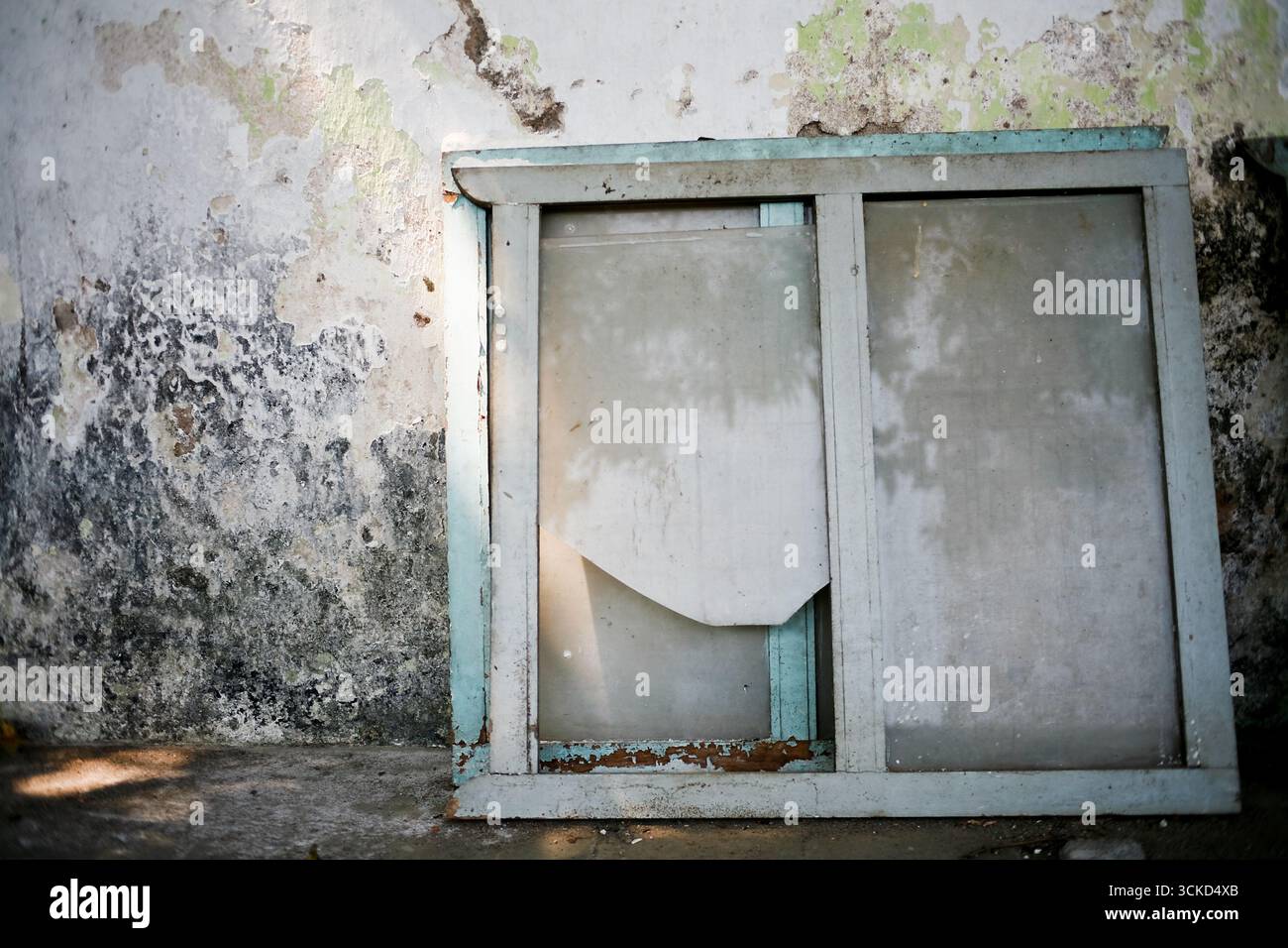 old window frame glass broken leaning on the wall Stock Photo