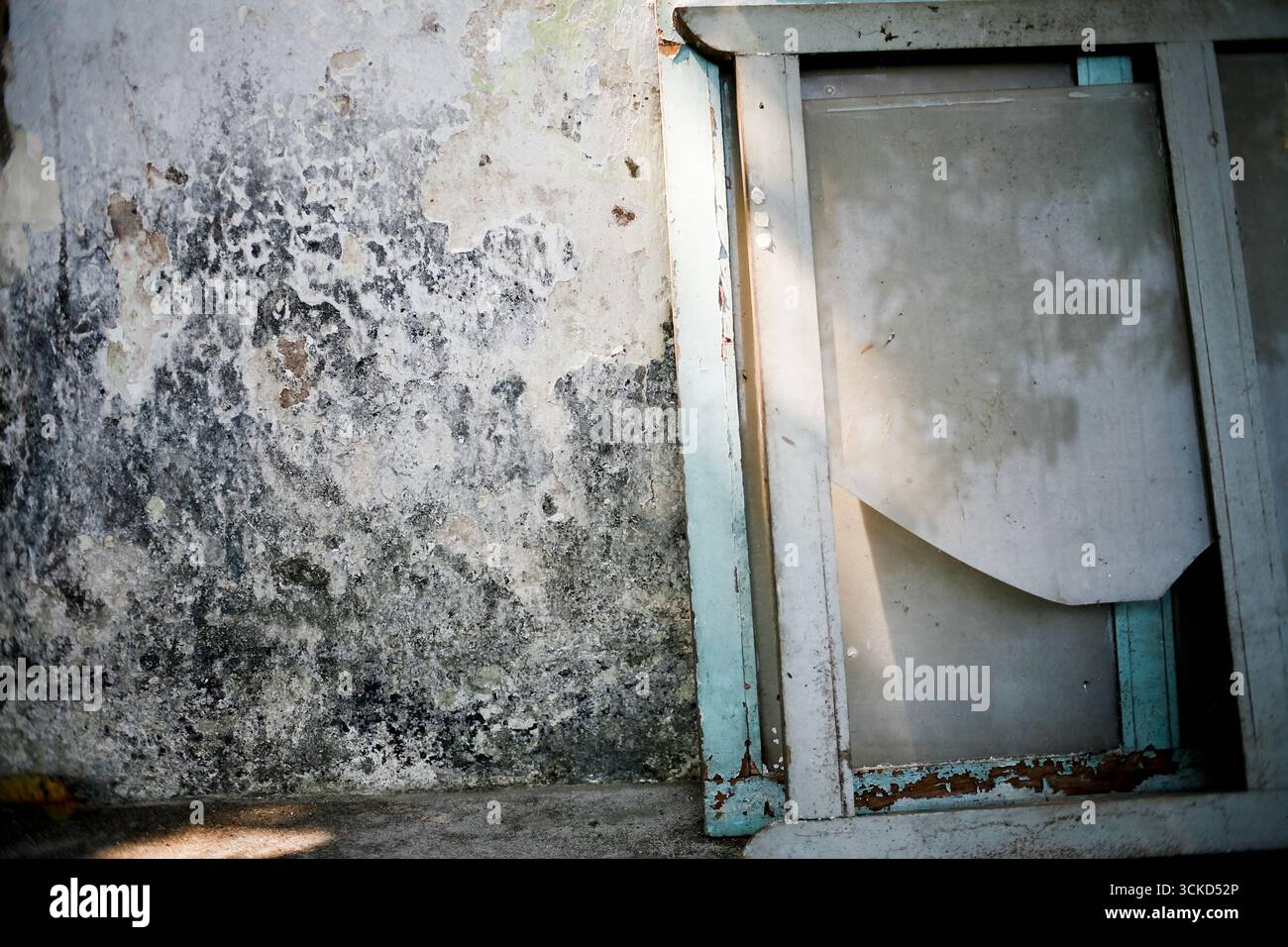 old glass window frame broken leaning on dirty wall Stock Photo