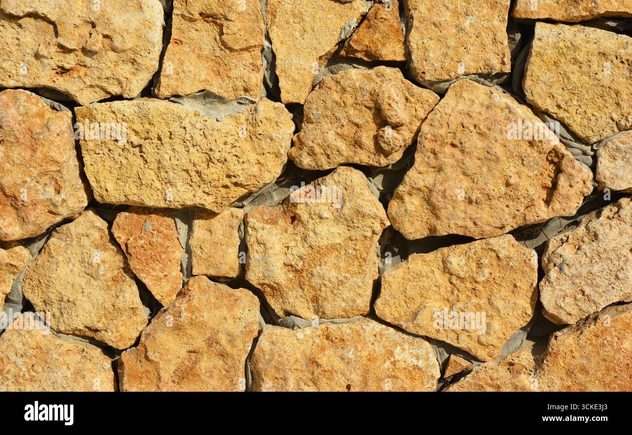 Wall made of wild stone and mortar with copy space. Stock Photo