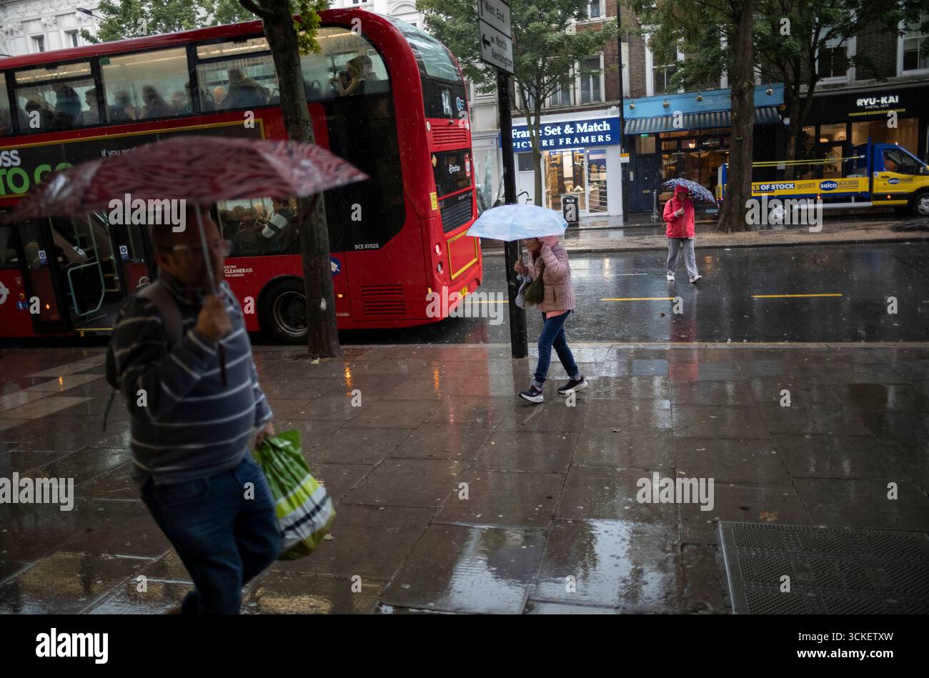 Autumn heavy rain showers catch out afternoon commuters and tourists at Notting Hill, West london, England, United Kingdom Stock Photo