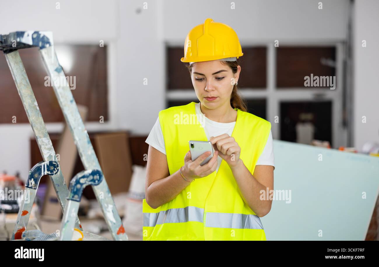 Young woman engineer using smartphone in construction site Stock Photo