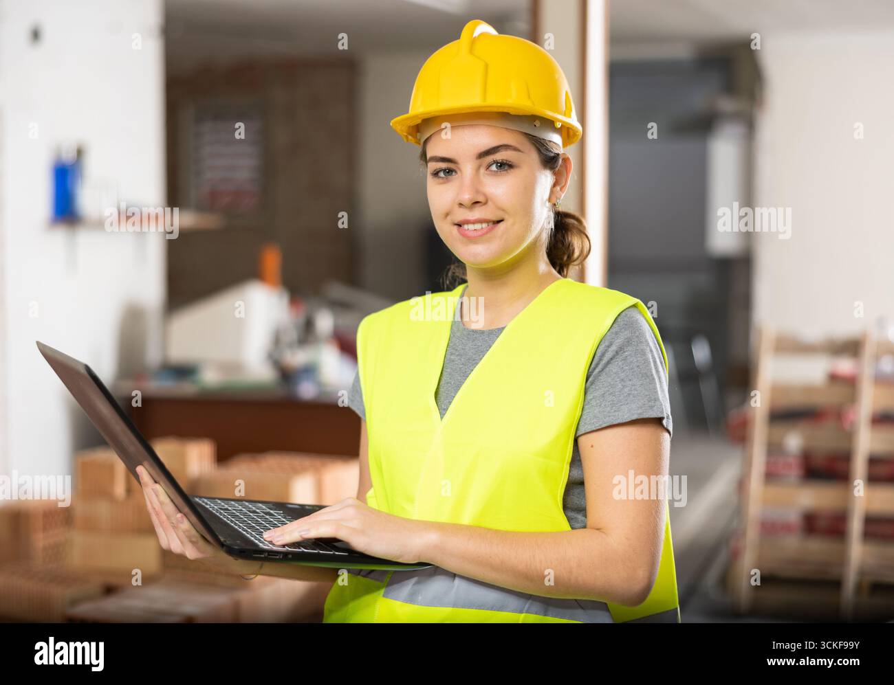 Female engineer using laptop in apartment Stock Photo