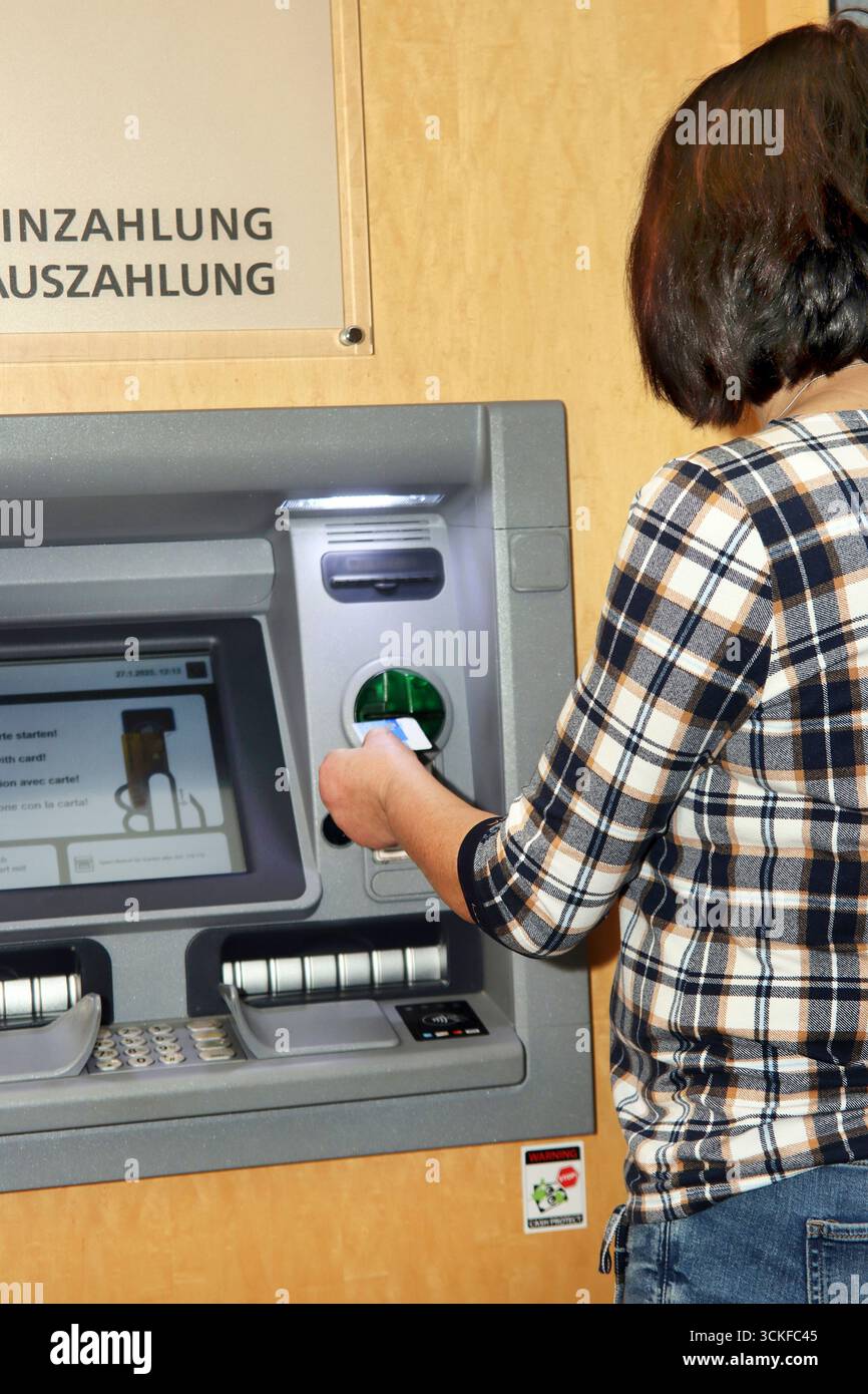 inserting an EC card into an ATM Stock Photo