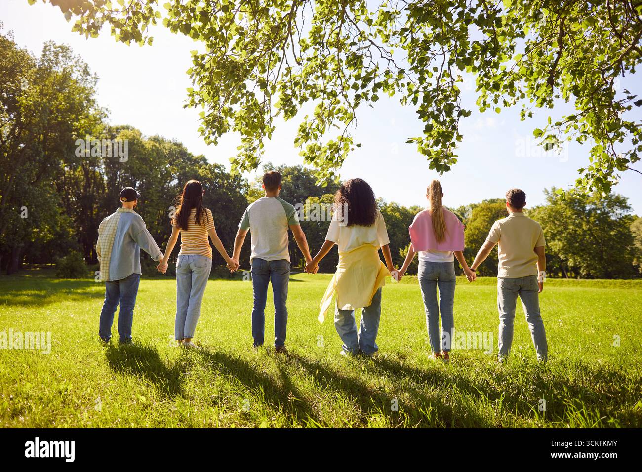 Group Of Friends Holding Hands In City Park Stock Photo - Alamy