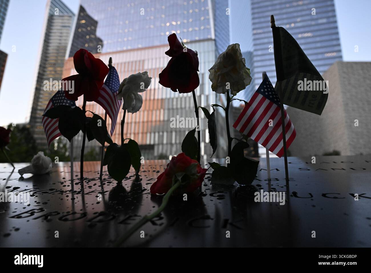American flags and flowers line the memorial pool at the National ...