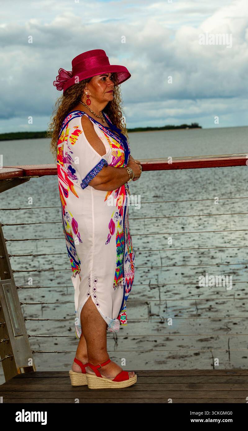 lady lookout pink hat colorful dress side hair hat looking right long curly brown hair 50 plus models mature models modelling australia australian Stock Photo