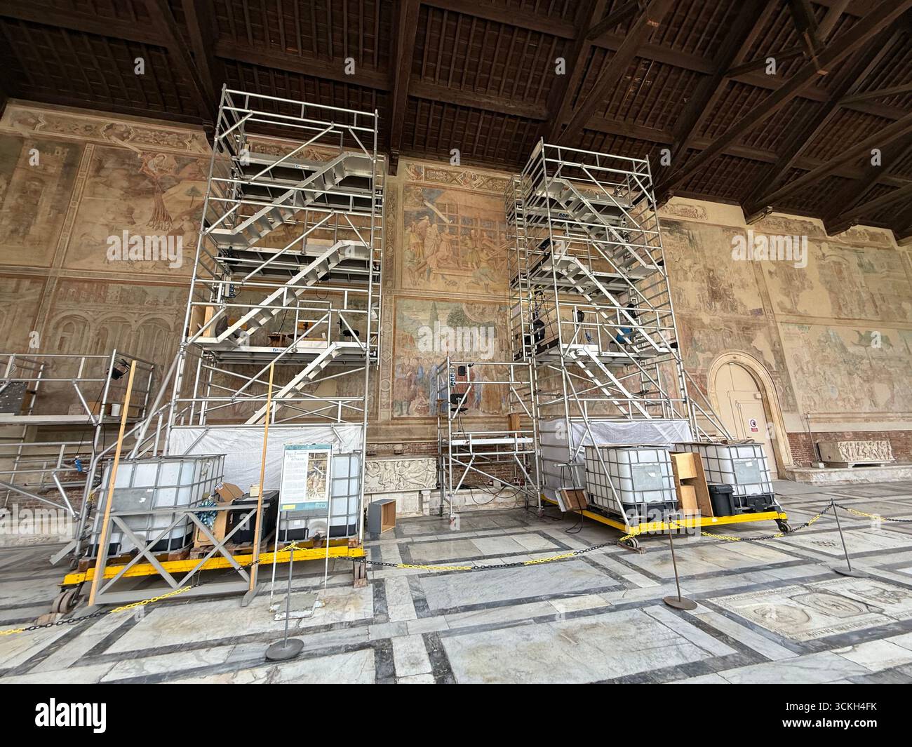 A scaffolding platform for skilled retouching artists for retouching faded colours back to life on a large centuries old wall painting inside the Camp - Smartphone Captured Stock Image