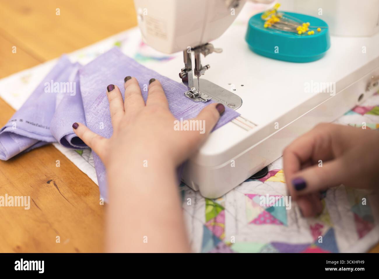 Close up of woman's hands using sewing machine Stock Photo