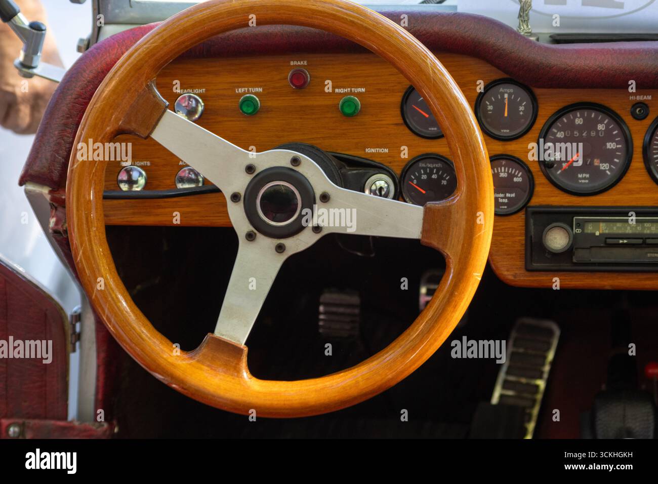 Close up of wooden steering wheel, dashboard, and gauges in vintage classic car, showcasing nostalgic automotive design Stock Photo