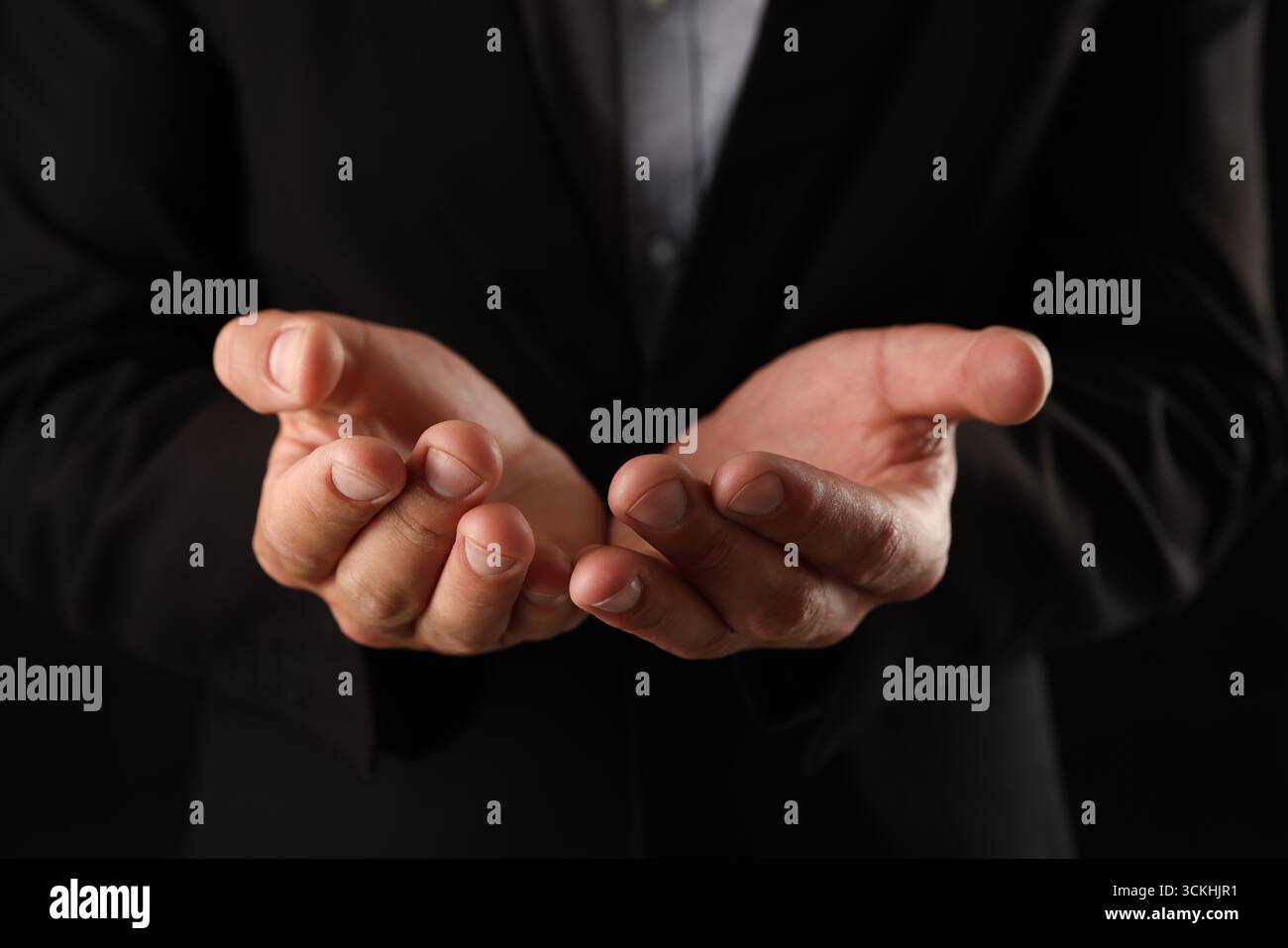 Man holding something on black background, closeup Stock Photo