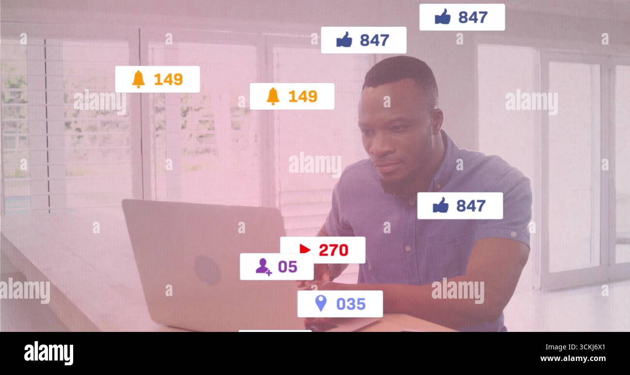 Working man in blue shirt typing on laptop at home office, with notification icons, copy space Stock Photo