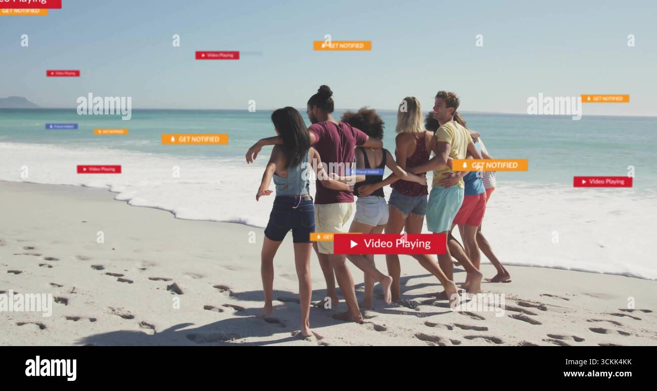 Walking group of seven friends along beach shoreline, with footprints ...
