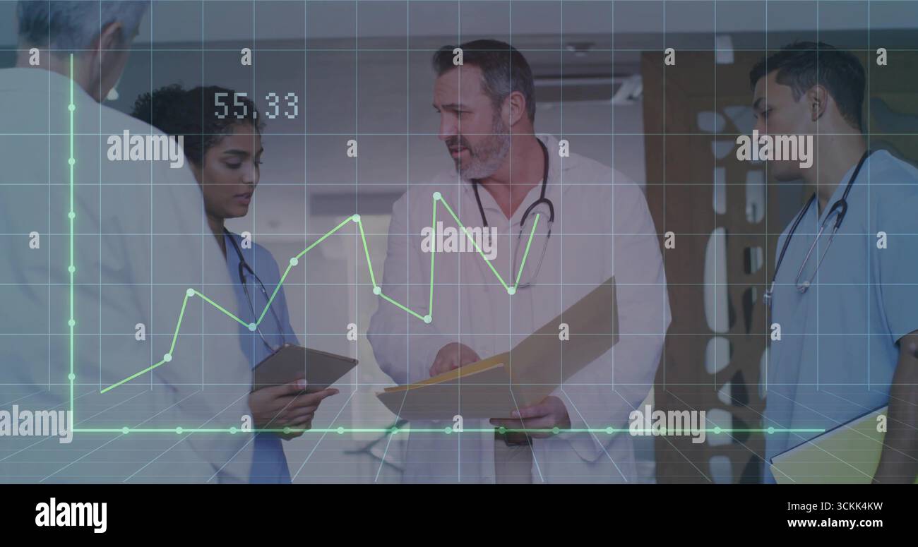 Medical team reviewing charts in hospital corridor, with tablet ...