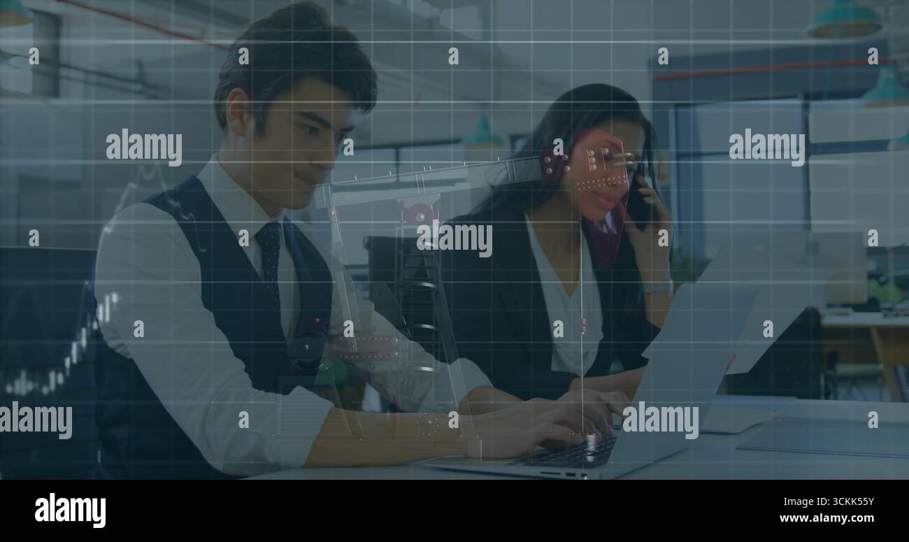 Collaborating professionals in business attire analyzing data at shared office desk, with laptops Stock Photo