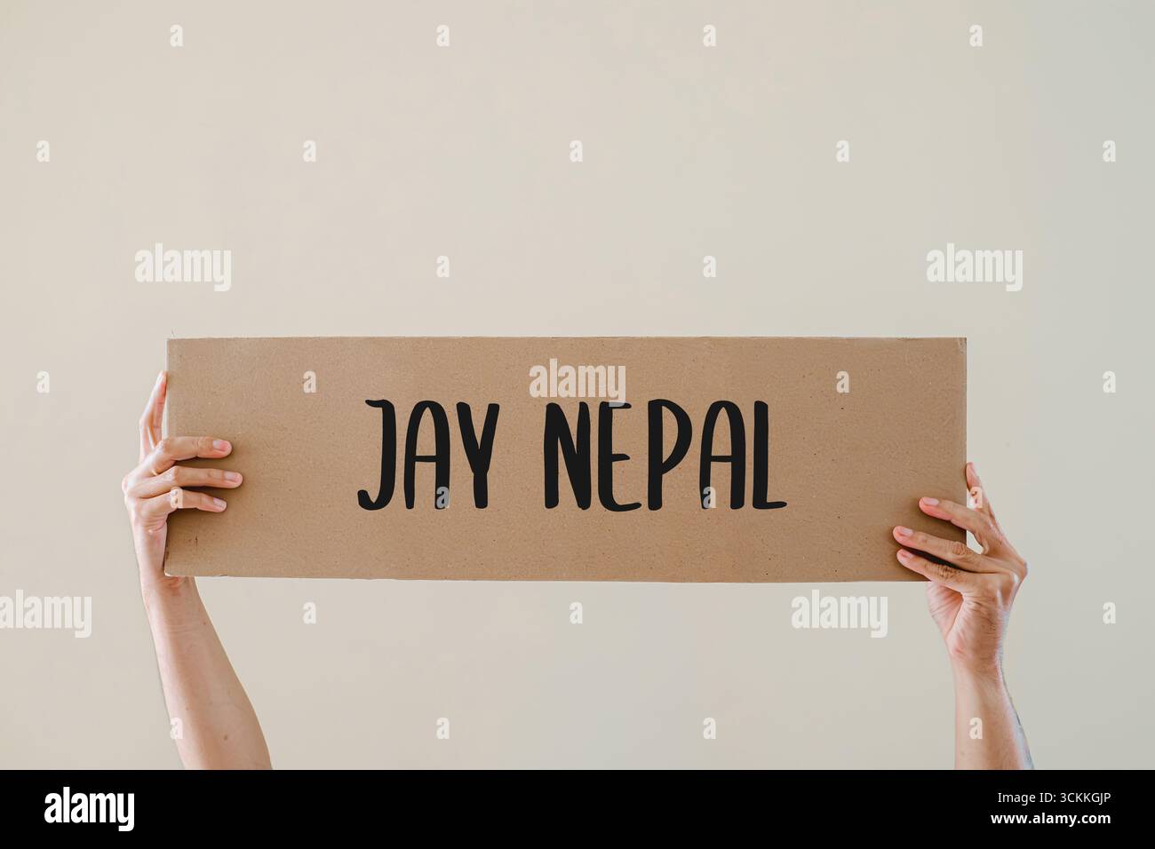 Hands holding a cardboard sign with text 