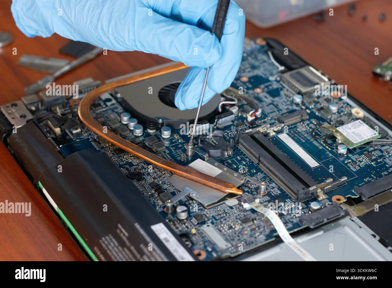 A technician is repairing the motherboard of a laptop computer. Stock Photo