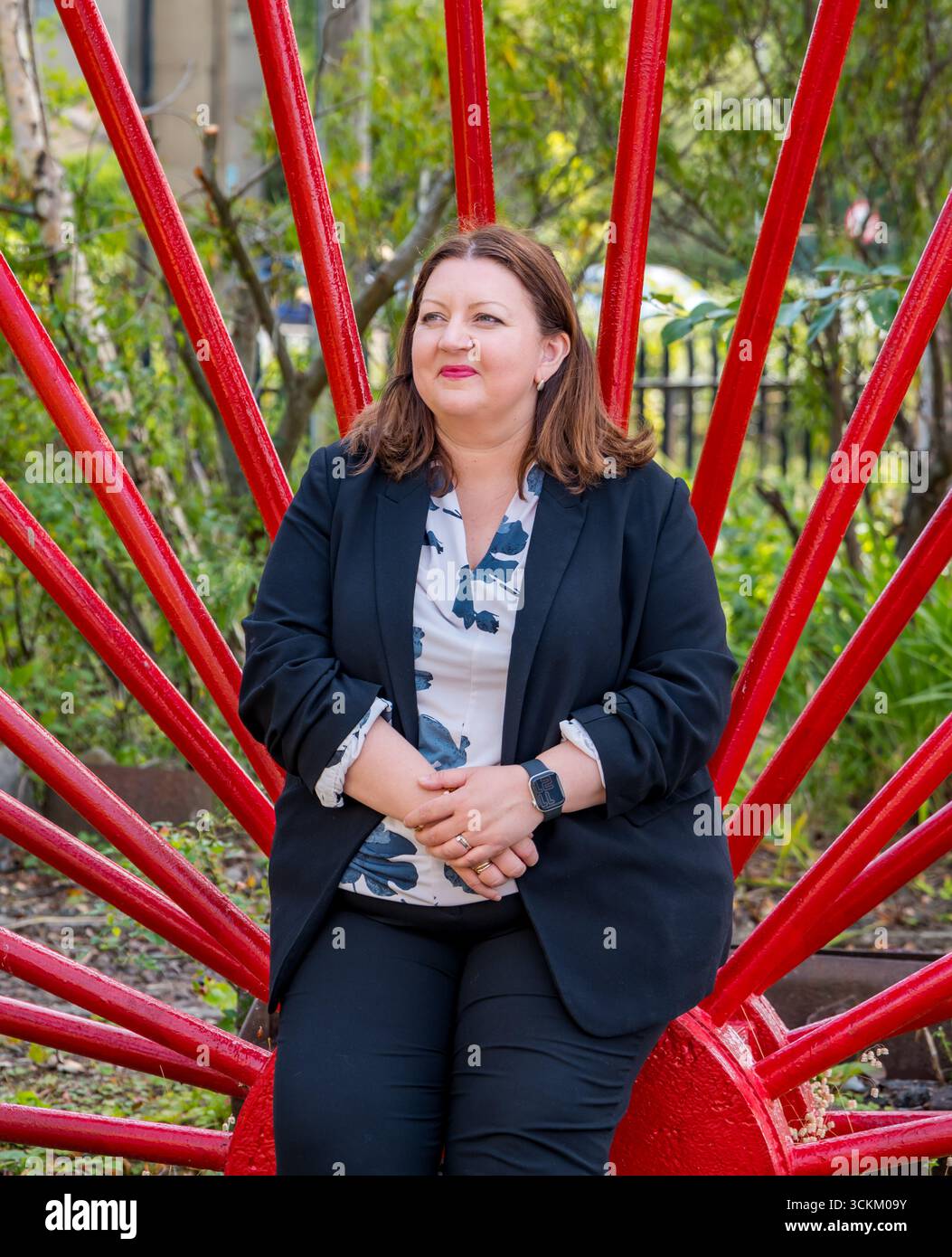 Portrait of Kirsty McNeill (Scottish Labour MP) with industrial wheel, National Mining Museum, Newtongrange, Midlothian, Scotland, UK Stock Photo