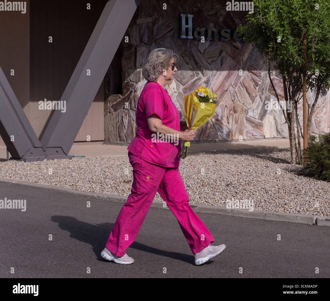 September 12, 2025, Phoenix, Arizona, USA: A woman carries flowers to a ...