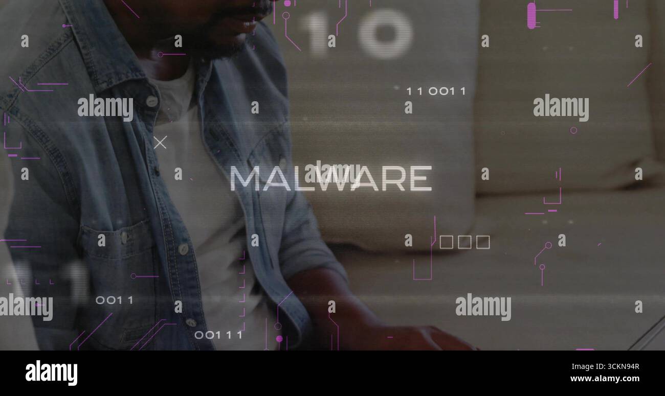 Typing man wearing denim jacket analyzing MALWARE binary code on laptop in living room, copy space Stock Photo
