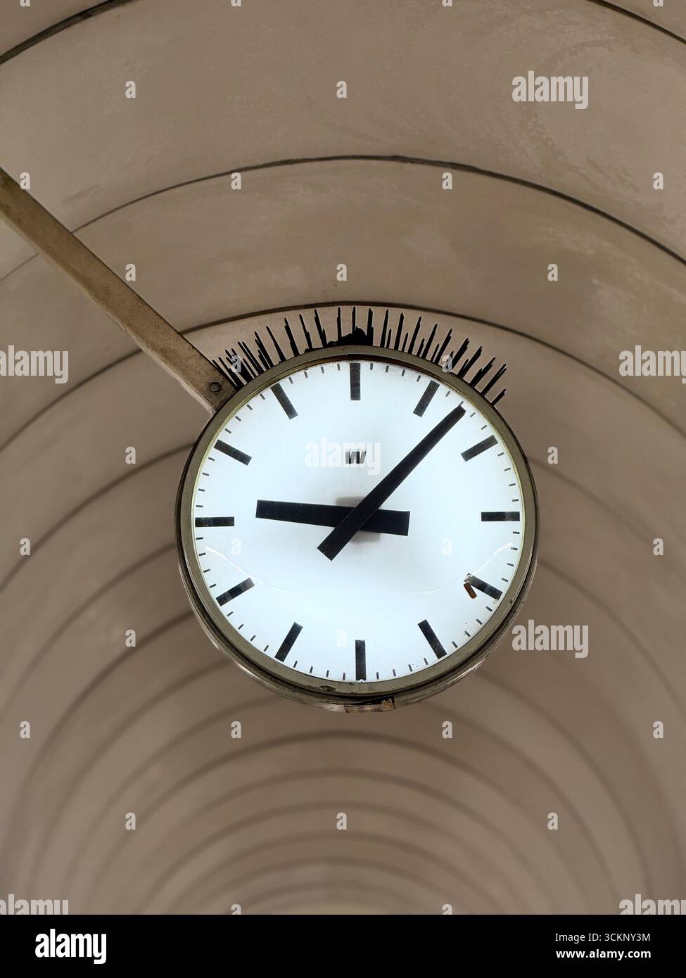 Analog clock under arched ceiling, photographed from below. - Smartphone Captured Stock Image
