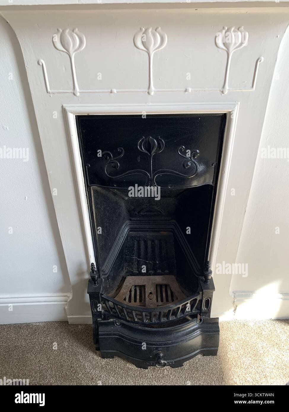 fireplace fire metal guard Victorian black old antique desiderative  design plaster white surround English British UK coal grate grating aged age - Smartphone Captured Stock Image