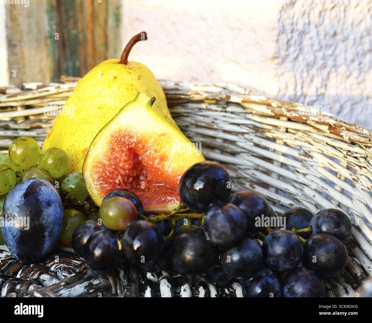Fig,Plum,Grapes,Pear in a white Basket Stock Photo