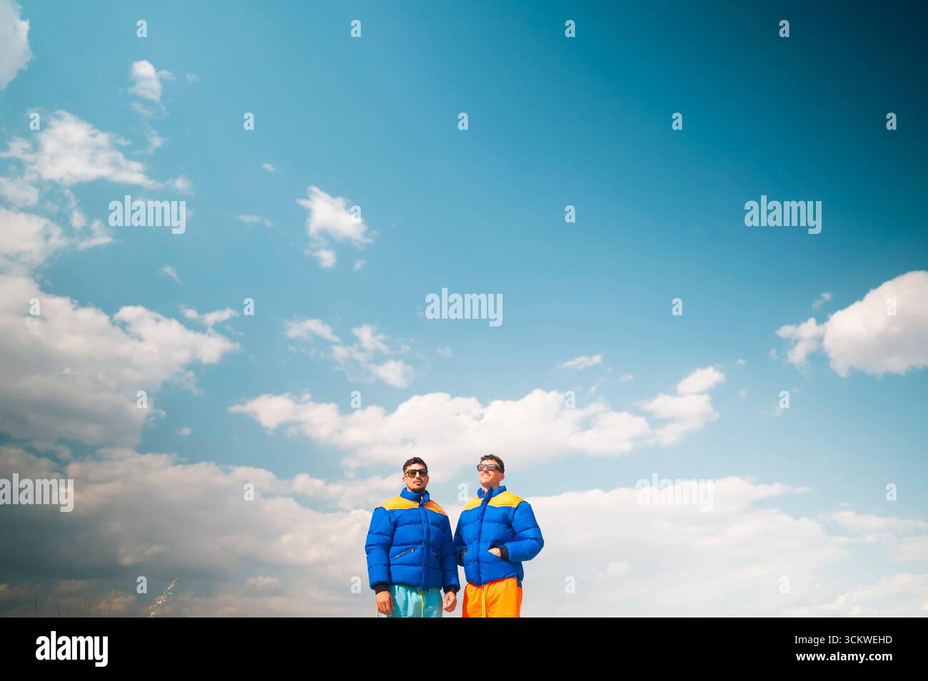 Two men in colorful jackets under blue sky Stock Photo