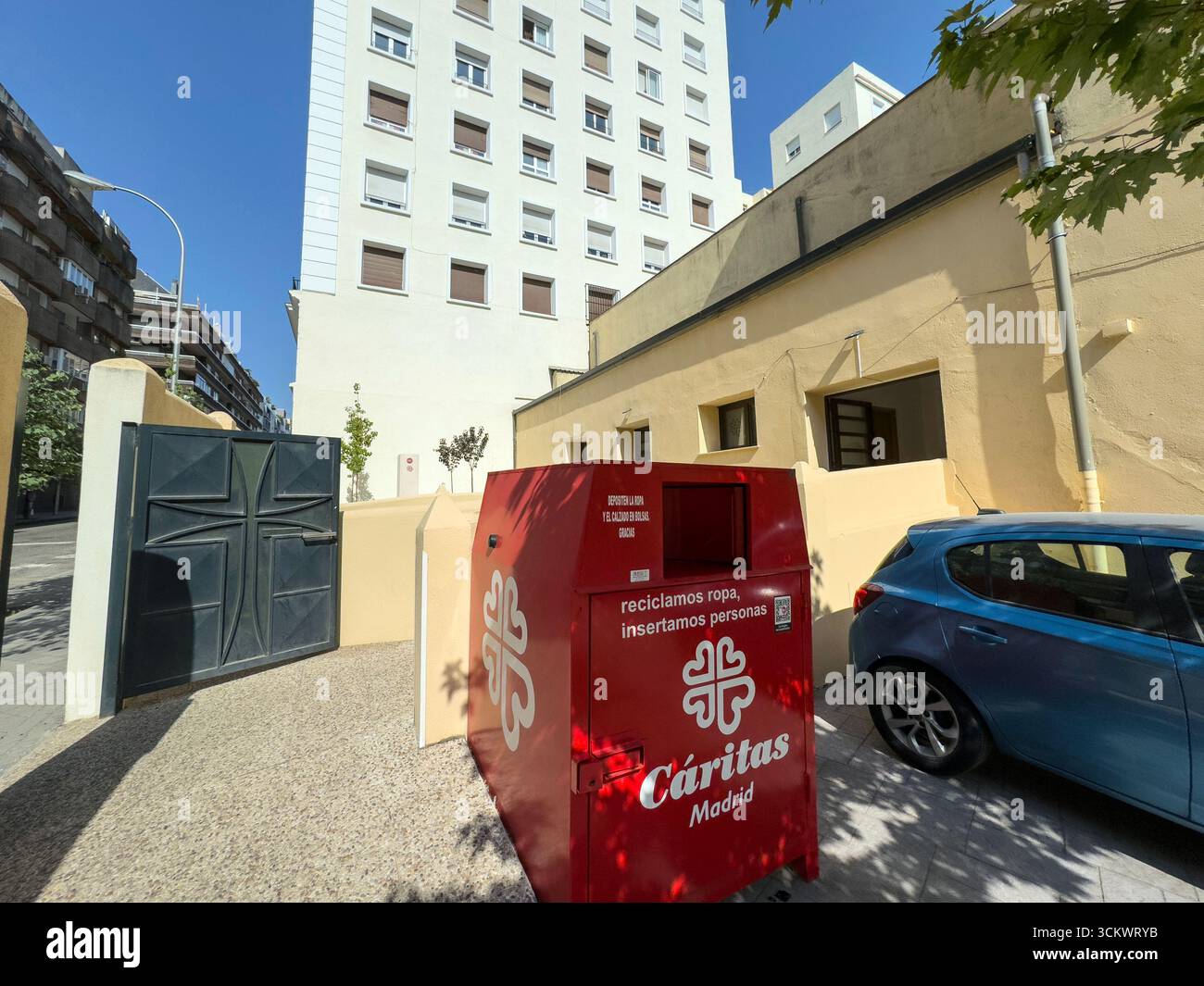 Caritas red second hand cloths, and shoes collection point in Chamberi, Madrid, Spain - Smartphone Captured Stock Image