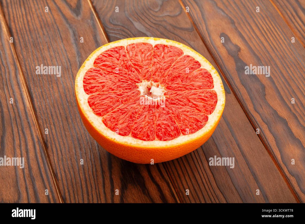 sliced grapefruit on brown wood background Stock Photo