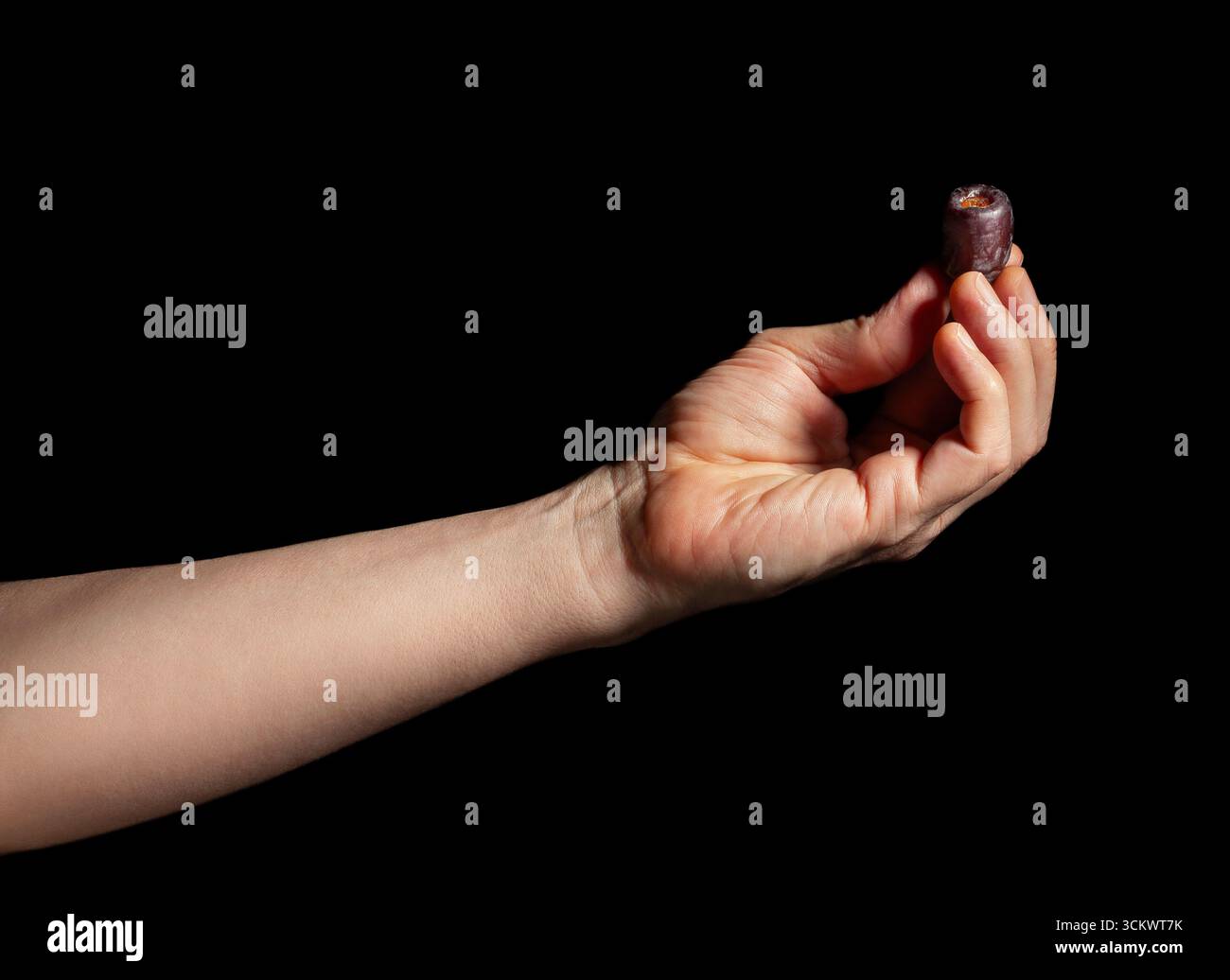 dates fruit in hand on black background Stock Photo