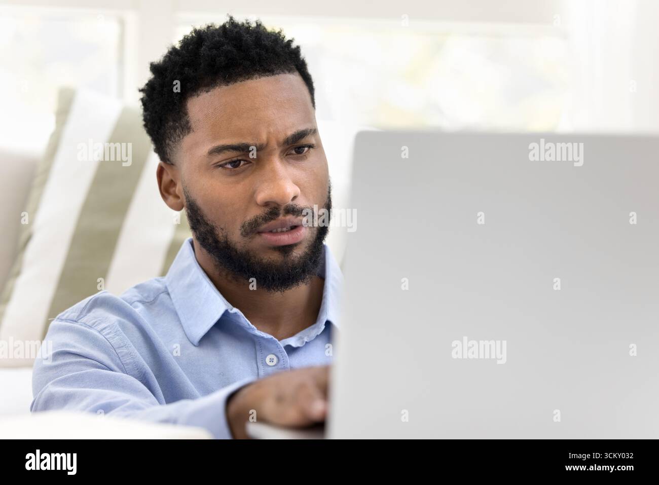 Closeup portrait young man working on notebook from home office Stock Photo