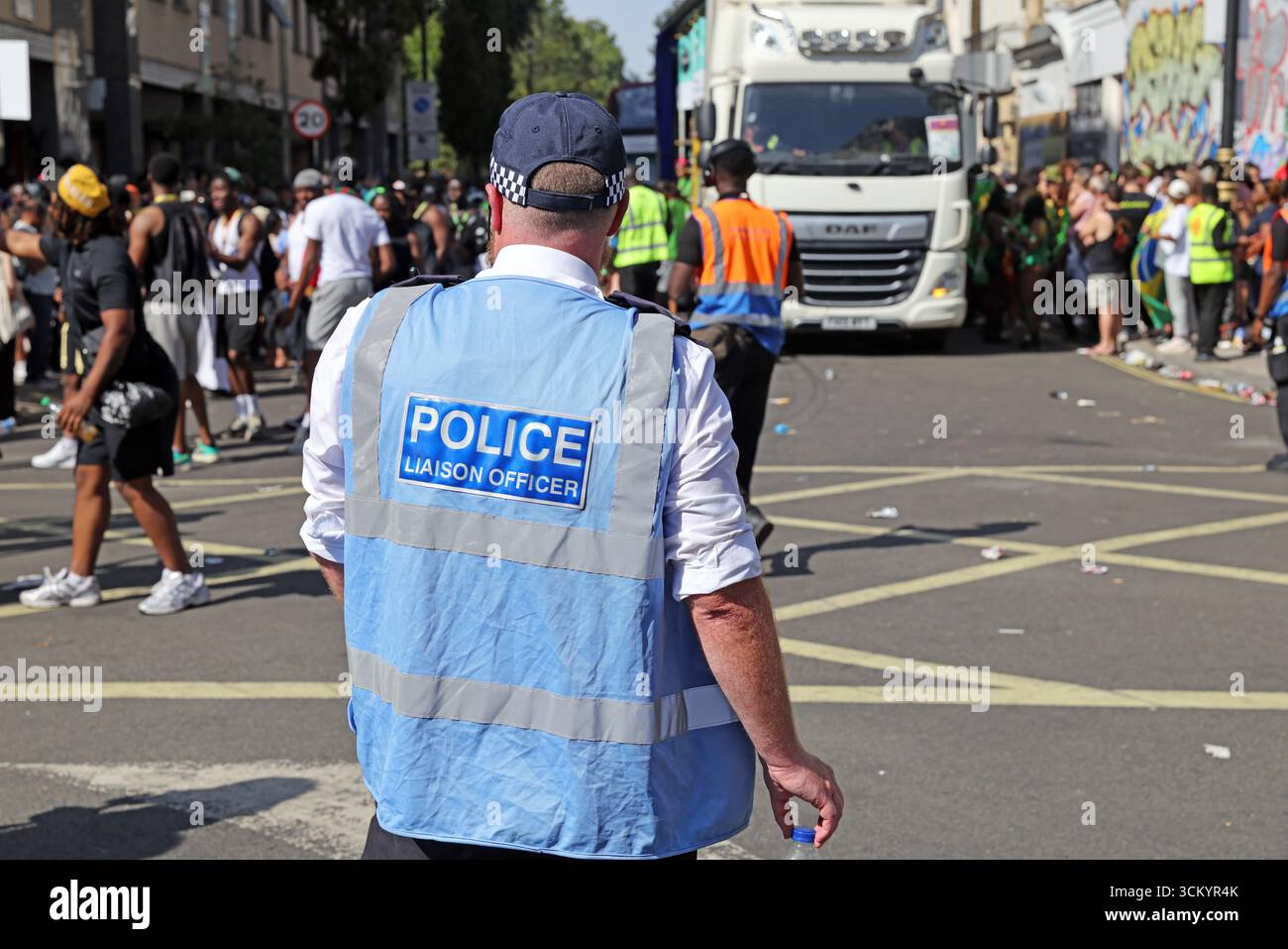 Police Liaison Officer from the Metropolitan Police Service monitors crowds during the Notting Hill Carnival in London, England Stock Photo