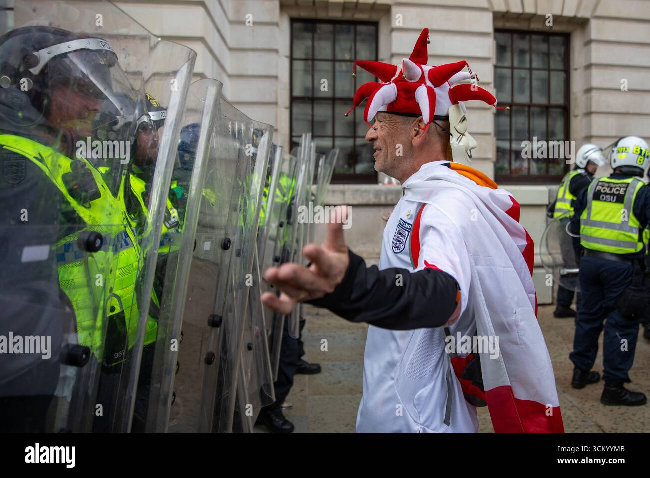 A protestor dressed as a jester stands in-front of the Metropolitan ...