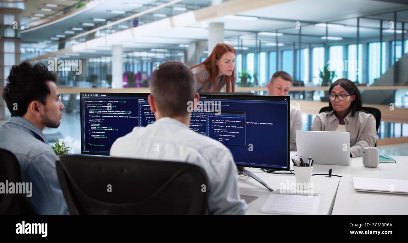 Multiracial Programmers Working Together On Coding Software In Modern Office Stock Photo