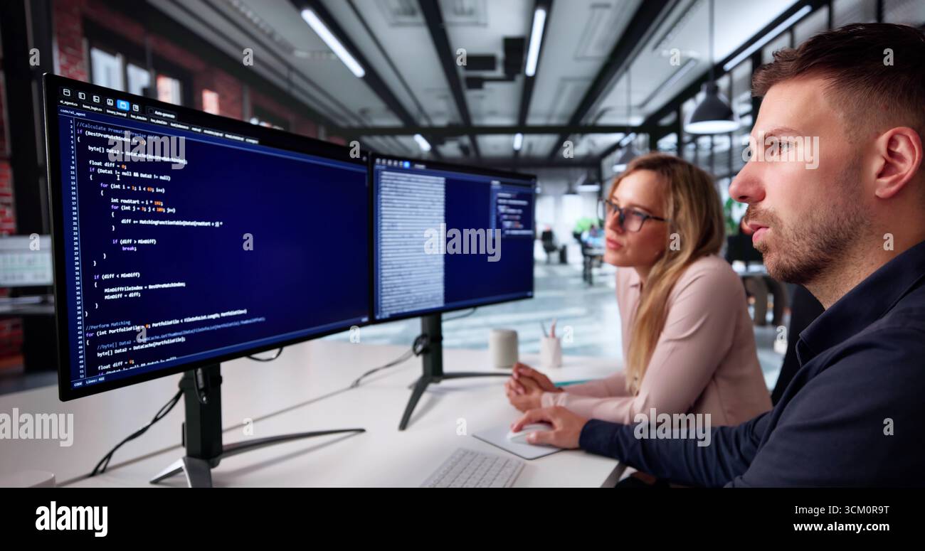 Busy Office: Man And Woman Coding Apps For Web Security Stock Photo