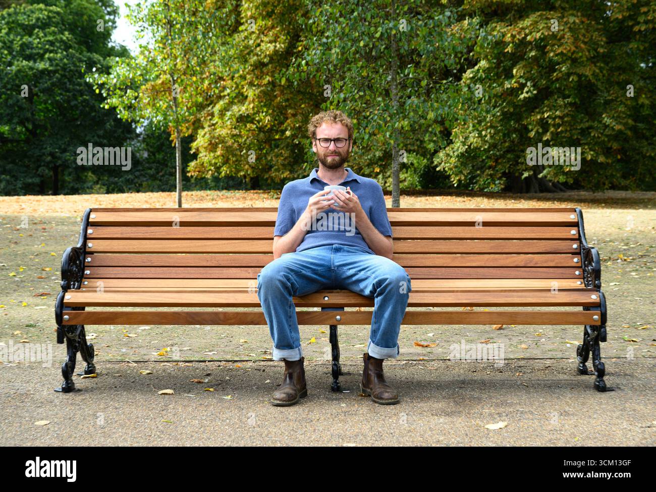 EMBARGOED TO 0001 MONDAY SEPTEMBER 15 EDITORIAL USE ONLY Documentary film maker 'A Mug of Life', real name William Shears, known on social media for his candid chats with strangers over tea on a bench, sits in Hyde Park, London, as he partners with McVitie's and Mind to encourage small but meaningful connections over tea and biscuits, following research that shows that more than two-fifths of people in the UK feel lonelier than five years ago. Issue date: Monday September 15, 2025. Stock Photo