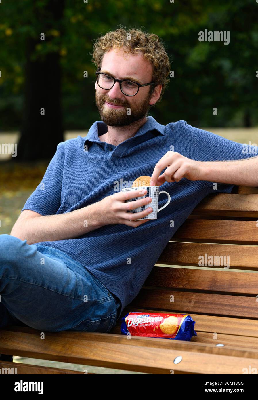 EMBARGOED TO 0001 MONDAY SEPTEMBER 15 EDITORIAL USE ONLY Documentary film maker 'A Mug of Life', real name William Shears, known on social media for his candid chats with strangers over tea on a bench, sits in Hyde Park, London, as he partners with McVitie's and Mind to encourage small but meaningful connections over tea and biscuits, following research that shows that more than two-fifths of people in the UK feel lonelier than five years ago. Issue date: Monday September 15, 2025. Stock Photo