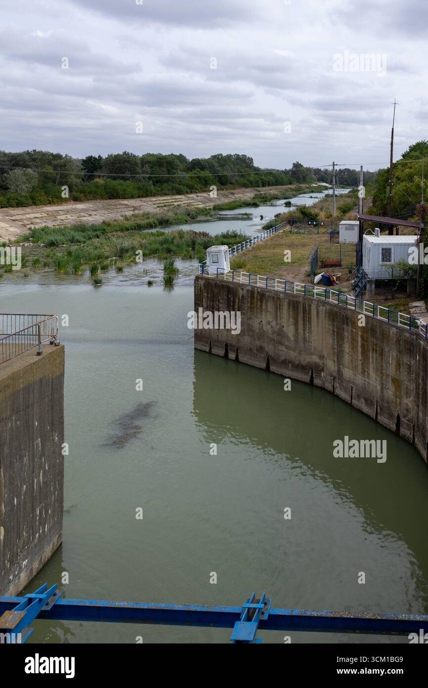 Industrial water dam and canal infrastructure with flowing river and ...