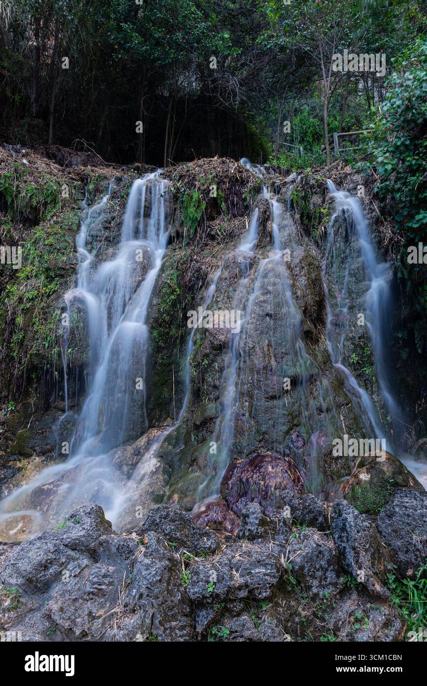 A vertical long-exposure image captures water cascading in multiple ...