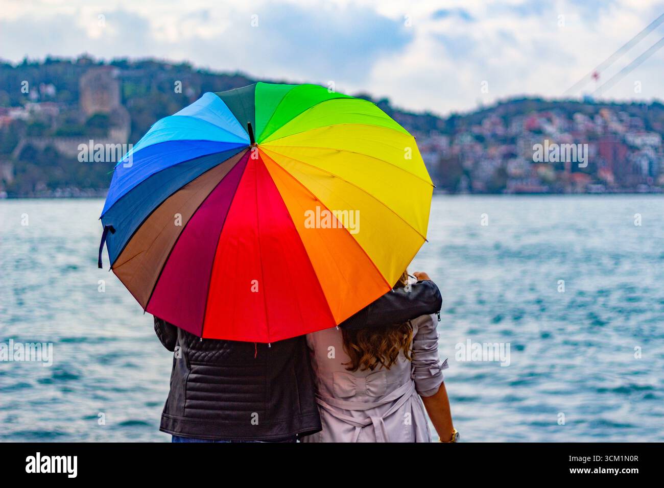 Couple with rainbow umbrella overlooking bosphorus Stock Photo