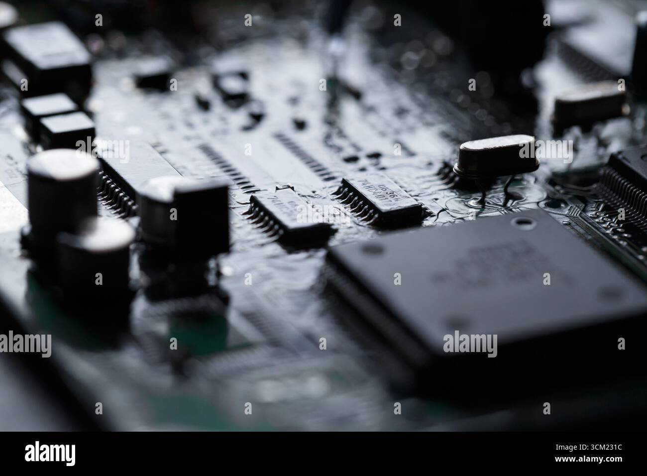 Close-up of an electronic printed  circuit board, many complex surface mounted components. Future dynamic modern technology and electronics. Back lit, Stock Photo
